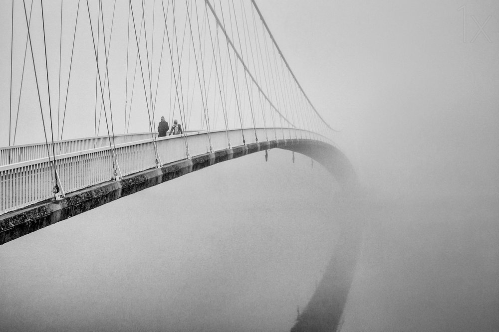 Mensen op een mistige brug door Krunoslav Nevistic