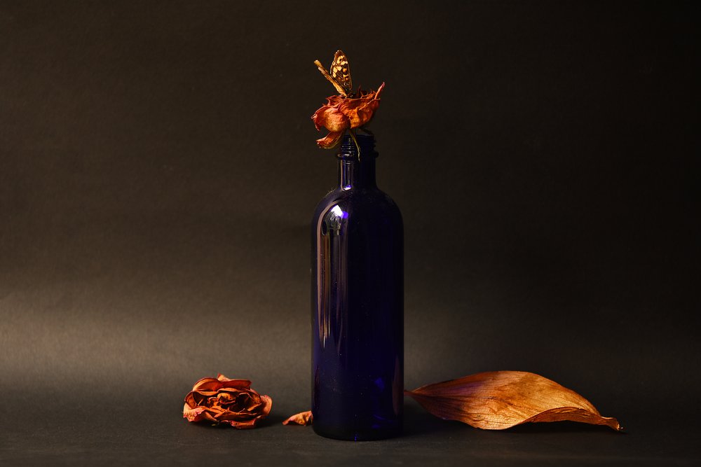 Gedroogde roos in een blauwe fles door Ludmila Shumilova