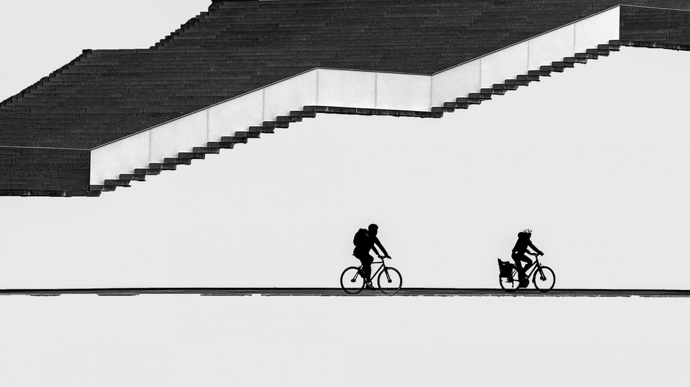 Fietsers in silhouet op de trap door Shanrui Ren