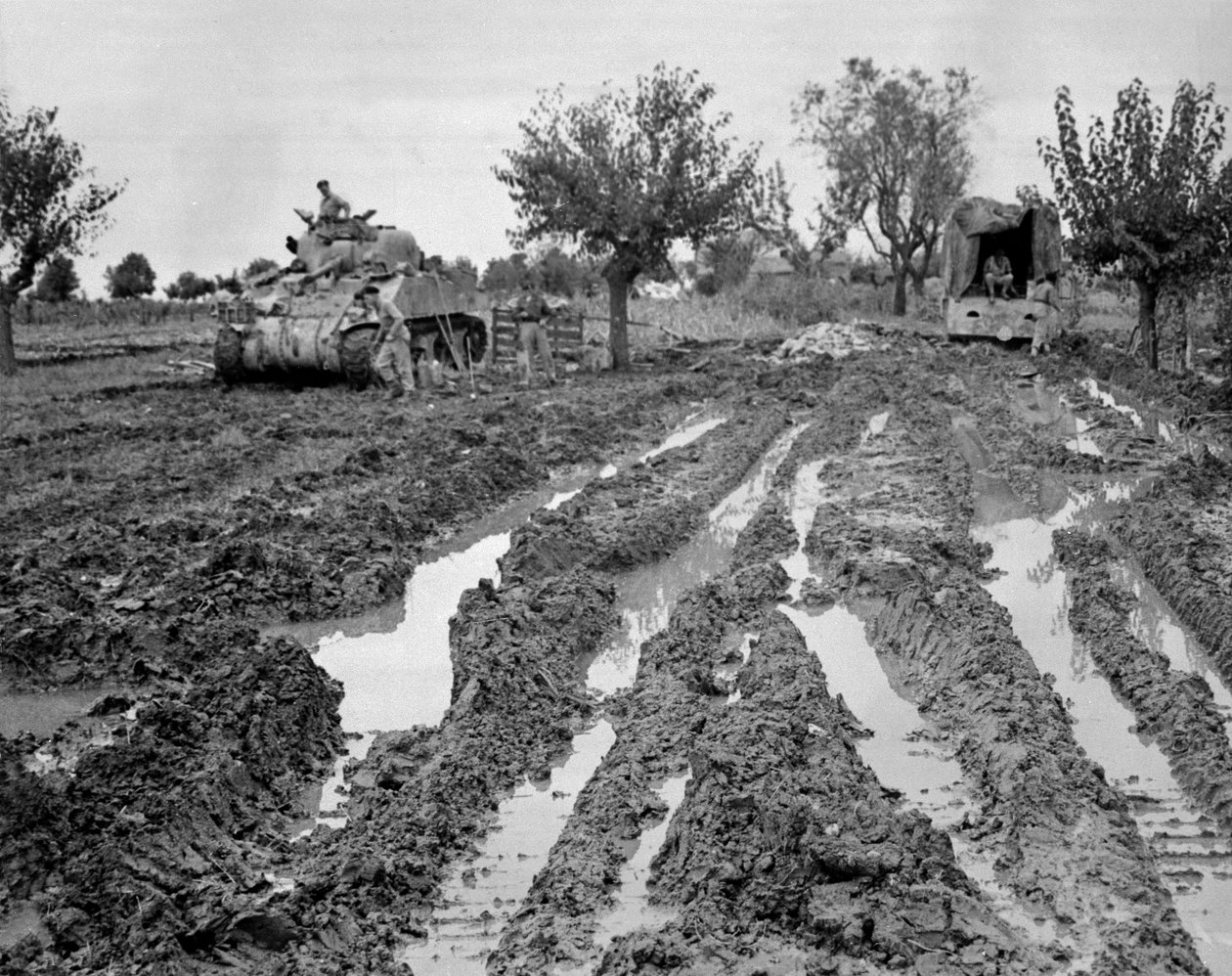 Sherman tank en een vrachtwagen in modderig terrein, Italië, ca. 1943-45 door American Photographer