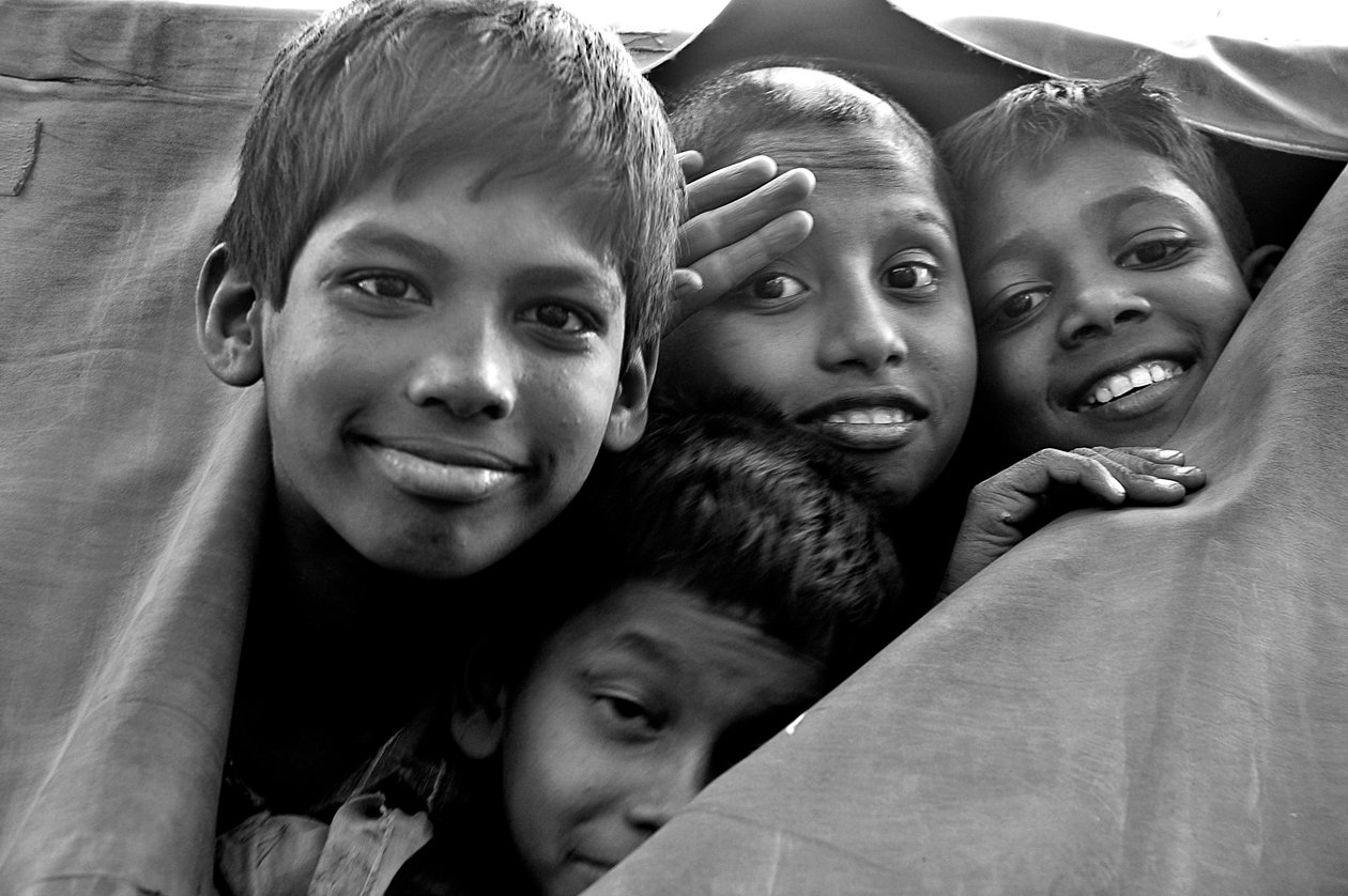Hulpeloze kinderen kijken door een gescheurde canvas van een politiewagen in Dhaka, Bangladesh. 26 november 2006 door Unknown