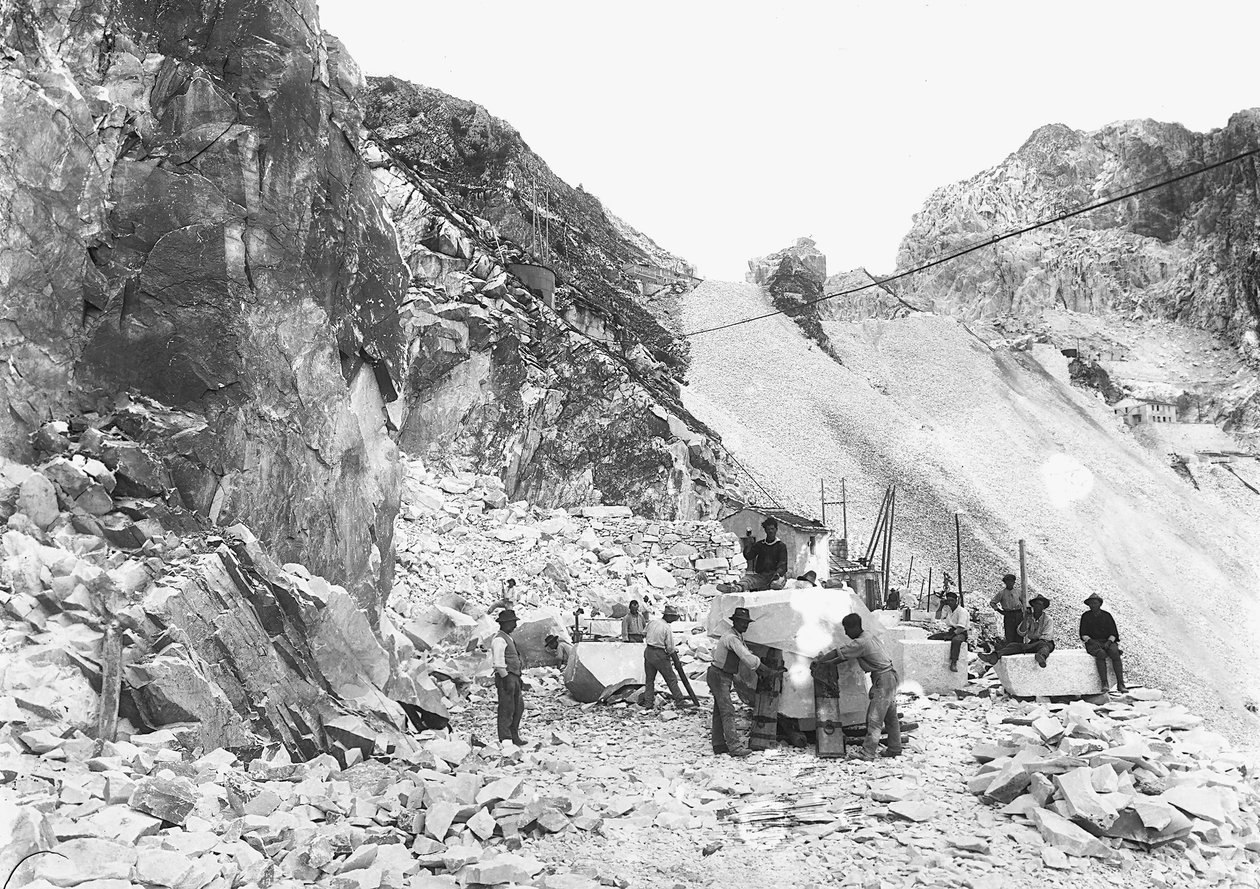 Gravers aan het werk in een marmergroeve in de Apuane Alpen, Toscane. Sommigen zitten op blokken marmer die al vierkant zijn gemaakt. door A. Corsini