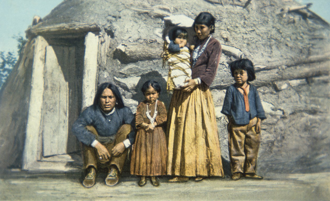 Ansichtkaart van een Navajo indianenfamilie buiten hun huis of 