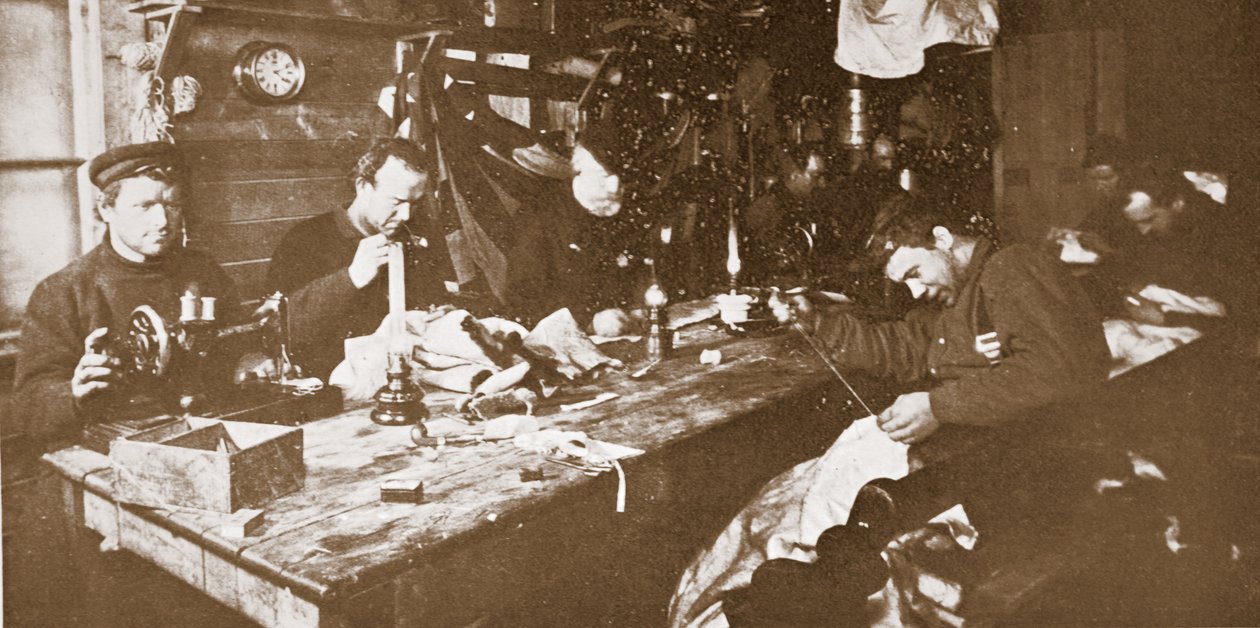 In de hut tijdens de midwinter, de mannen bezig met het naaien van bont voor kleding voor gebruik in de lente, uitgegeven Londen 1907 (zwart-wit foto) door Anthony Fiala