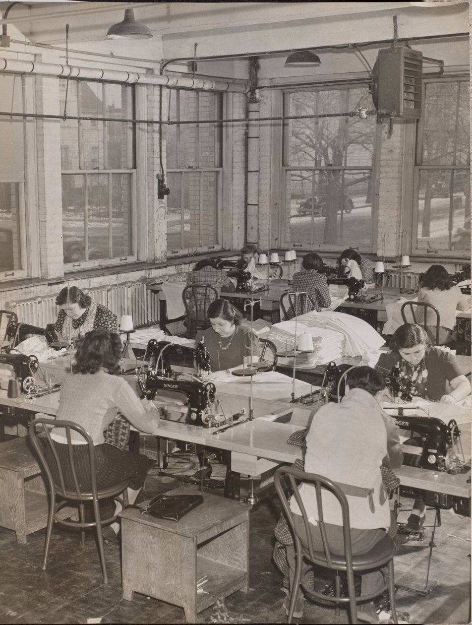 [Vrouwen aan bureaus werken aan naaimachines]. door Arnold Eagle
