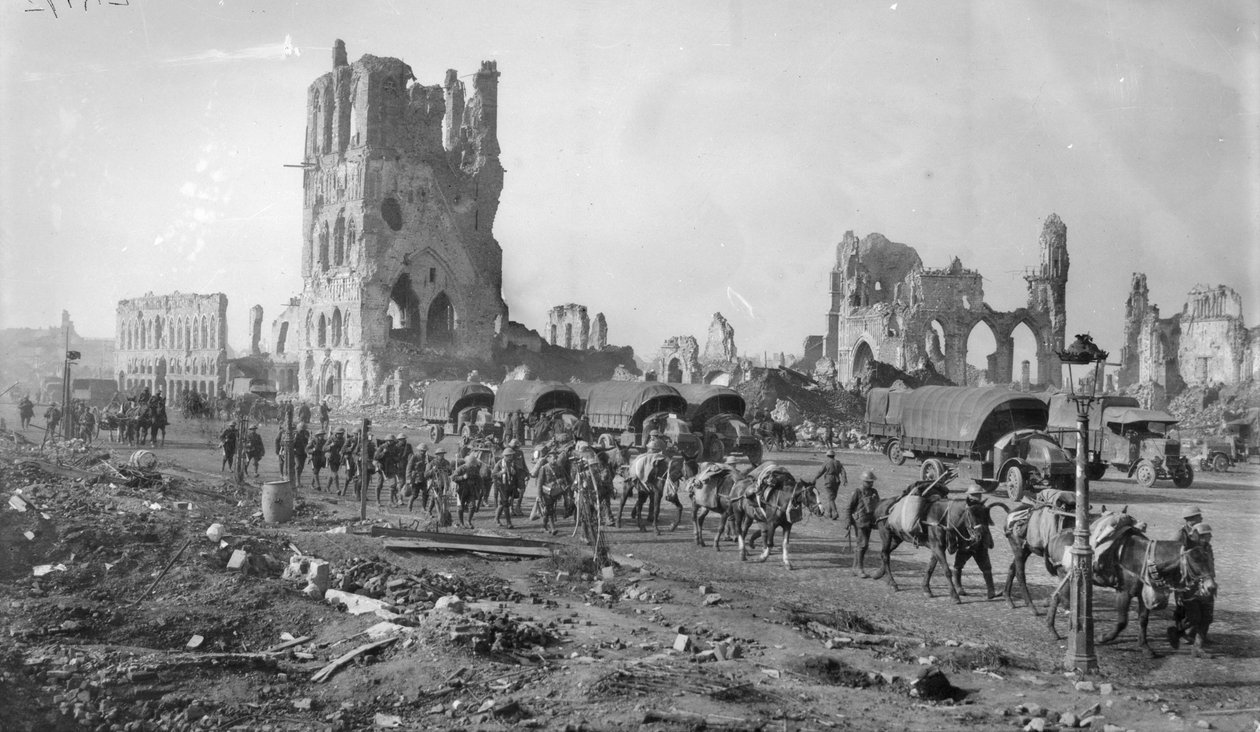 Een niet-geïdentificeerde Australische machinegeweersectie met bepakte paarden die de ruïnes van de Lakenhal passeren. Let op de geparkeerde motorvrachtwagens op de achtergrond, 19 oktober 1917 door Australian Photographer