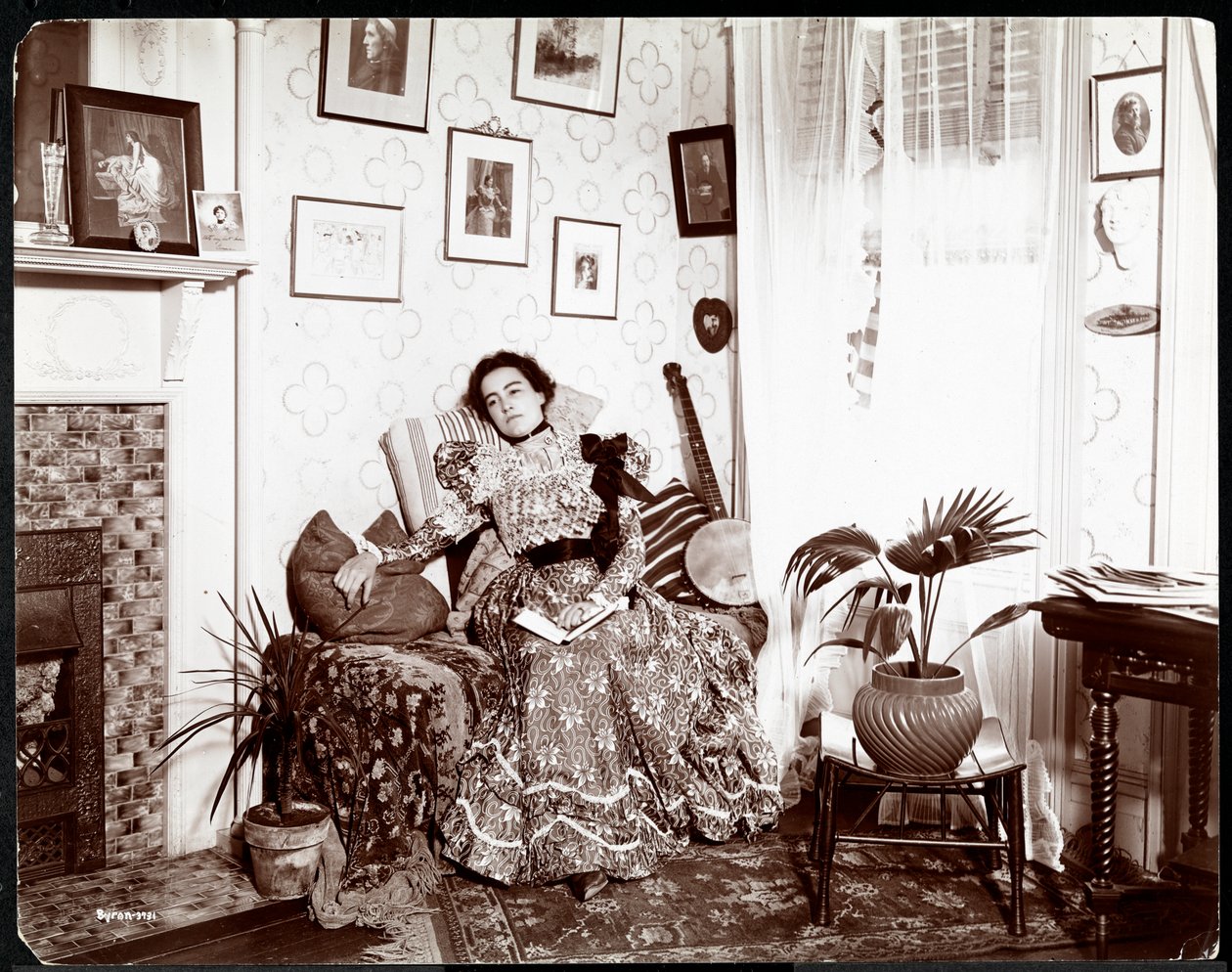 Een vrouw die in een stoel ligt en een boek leest, 1896-98 door Byron Company