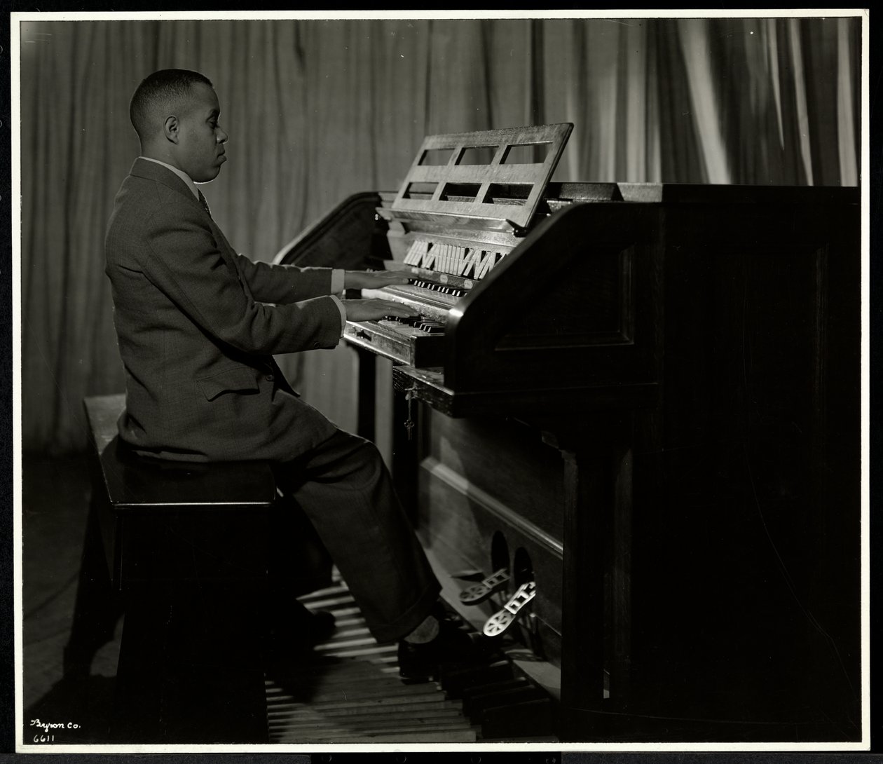 Afrikaanse Amerikaanse man speelt orgel bij de New York Association for the Blind, 111 East 59th Street, New York, 1934 door Byron Company