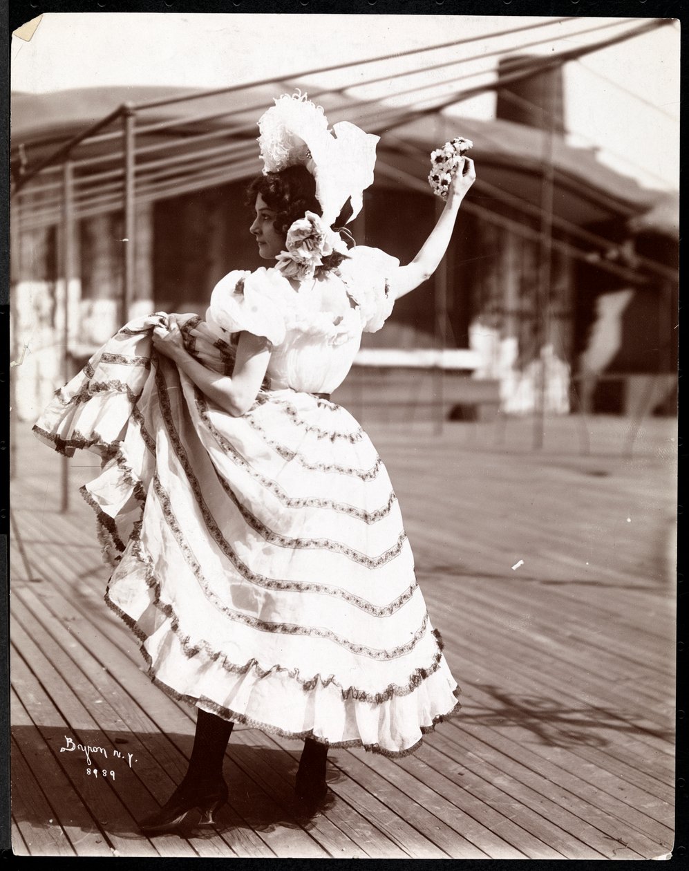 Een actrice in kostuum repeteert op het dak van wat waarschijnlijk het New York Theatre is, New York, 1900 door Byron Company
