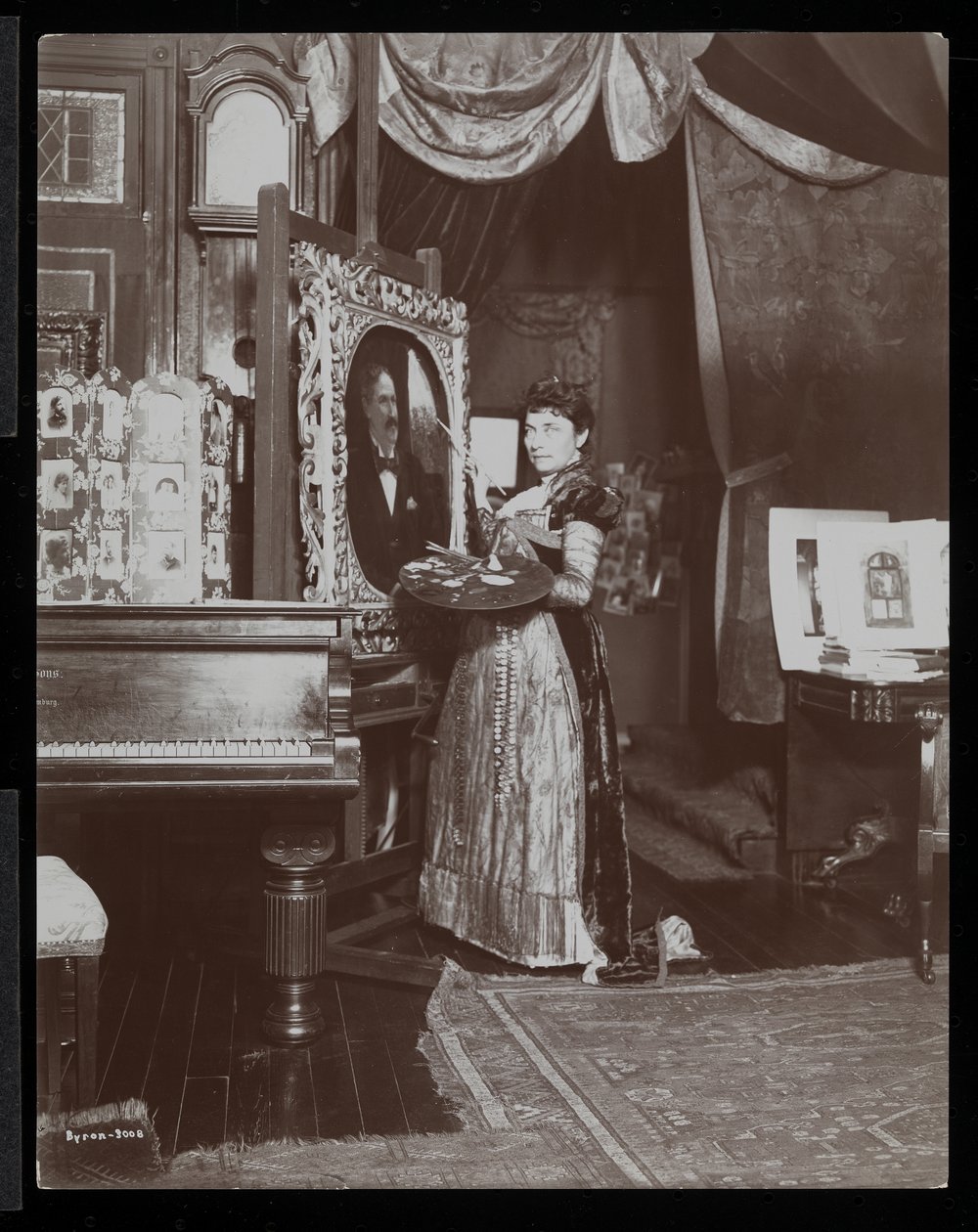 Kunstenares Mary Tillinghast schildert een portret in haar studio, New York, c.1897 door Byron Company