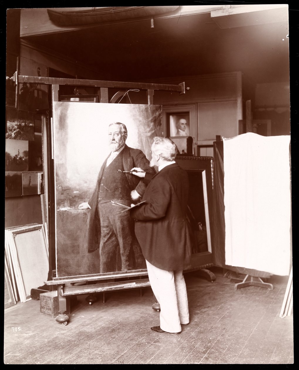 Eastman Johnson met penseel in de hand, werkend aan een portret van president Harrison in zijn studio, New York, 1895 door Byron Company