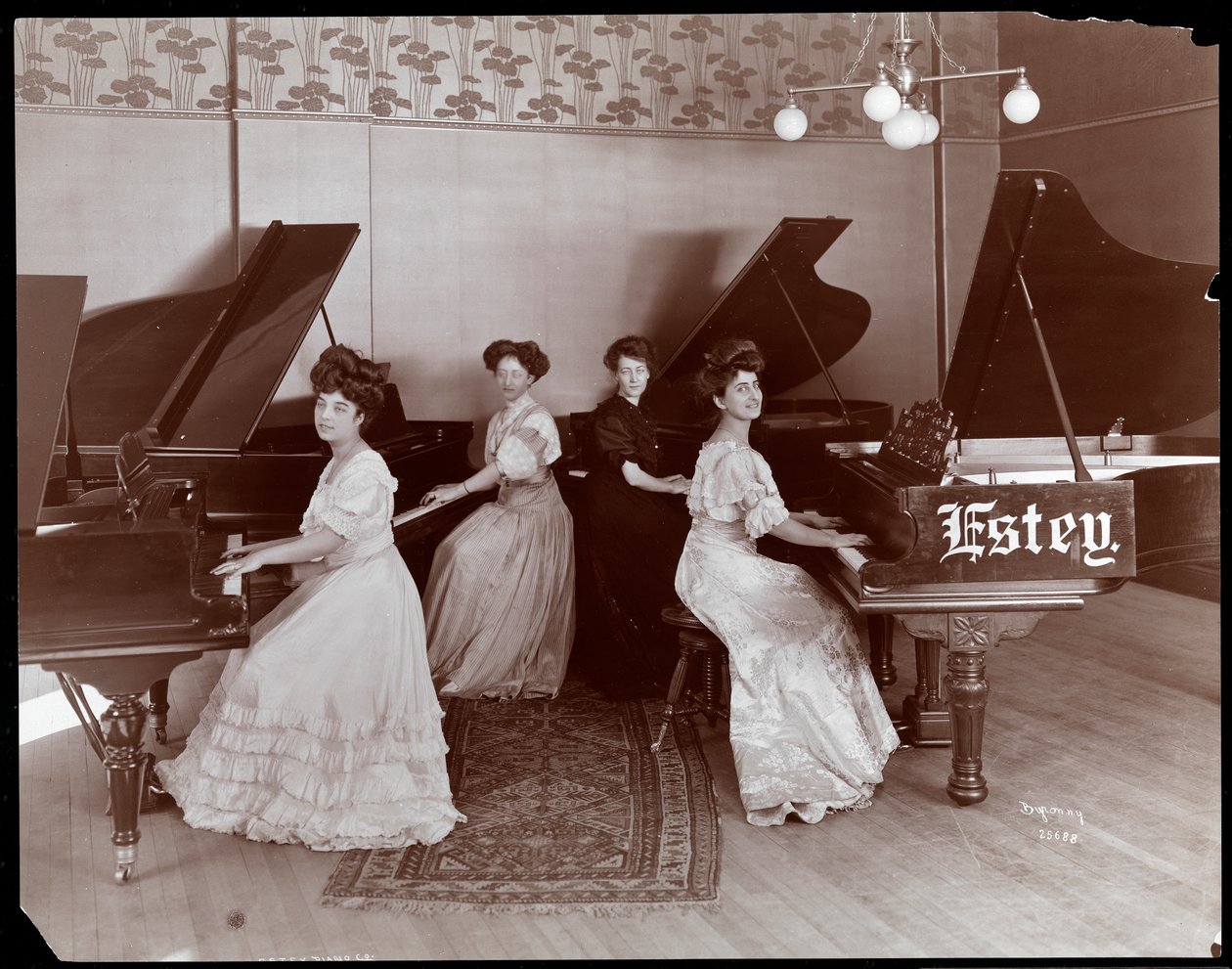 Vier vrouwen zittend aan piano
