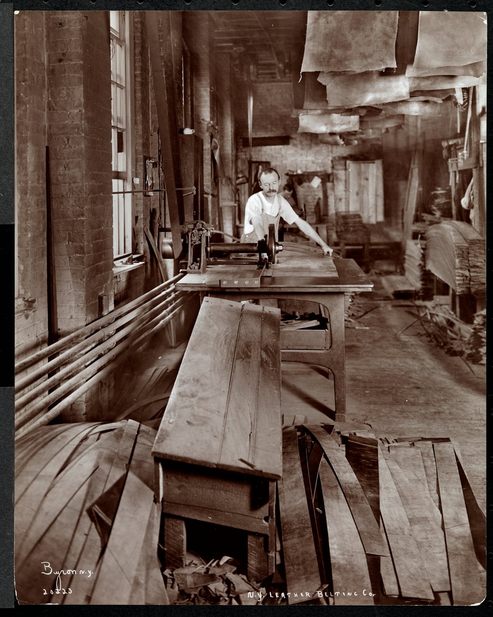 Interieur van een man die werkt met leer bij de New York Leather Belting Co., New York, 1905 door Byron Company