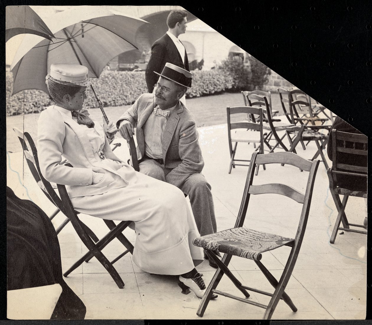 Man en vrouw zittend buiten op klapstoelen met vrouw die een parasol vasthoudt, Narragansett, Rhode Island, 1891 door Byron Company