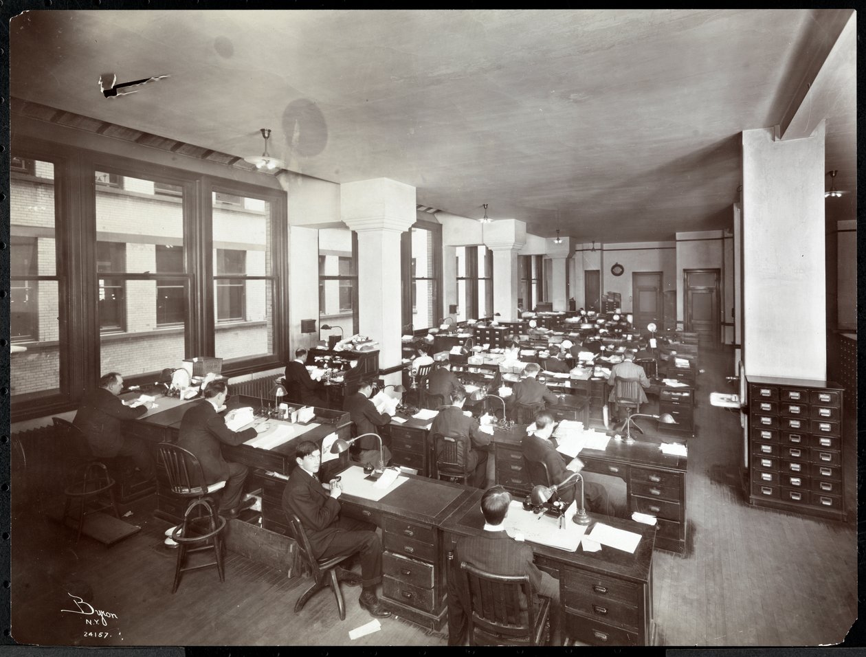 Mannen en een Vrouw die Werken aan Bureaus in een Kantoor van de Metropolitan Life Insurance Co. aan 23rd Street en Madison Avenue, New York, 1907 door Byron Company