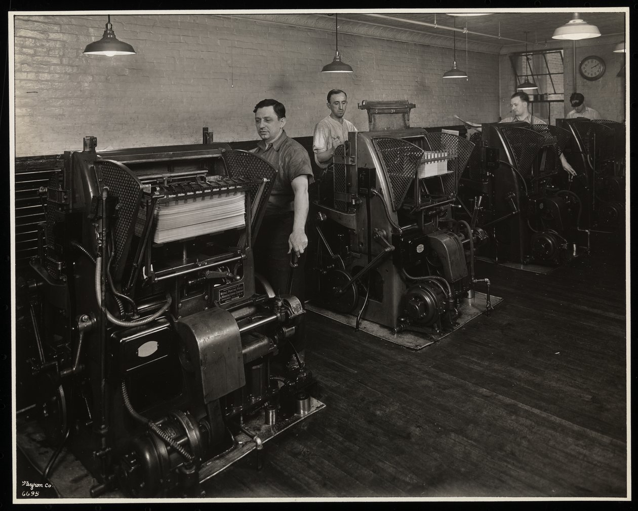 Mannen werken aan drukpersen bij Unz und Co., 24 Beaver Street, New York, 1932 door Byron Company