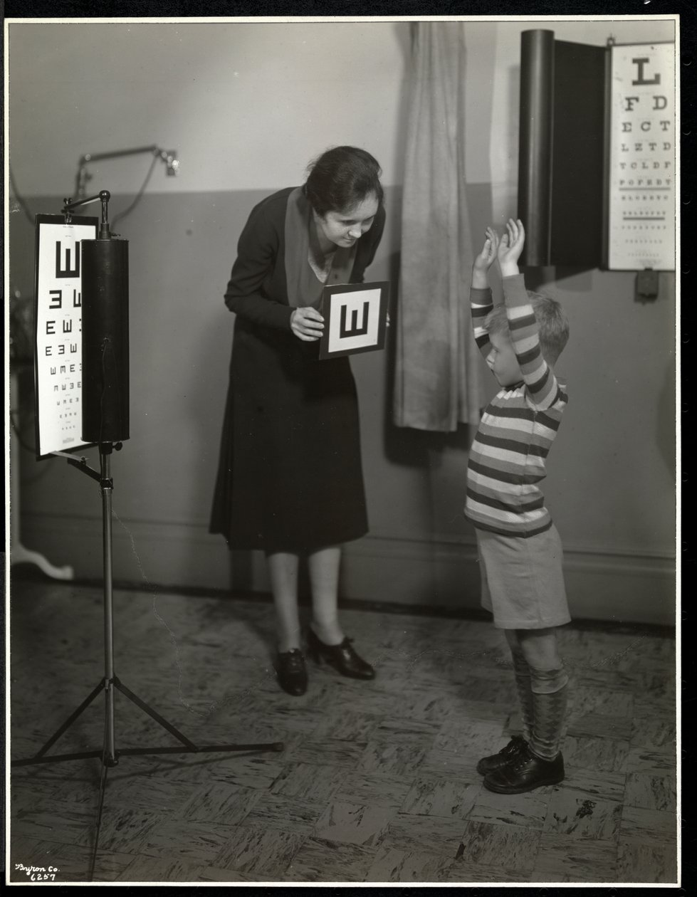 Verpleegster en een jongen die een oogtest ondergaat bij de New York Association for the Blind, 111 East 59th Street, New York, 1930 door Byron Company