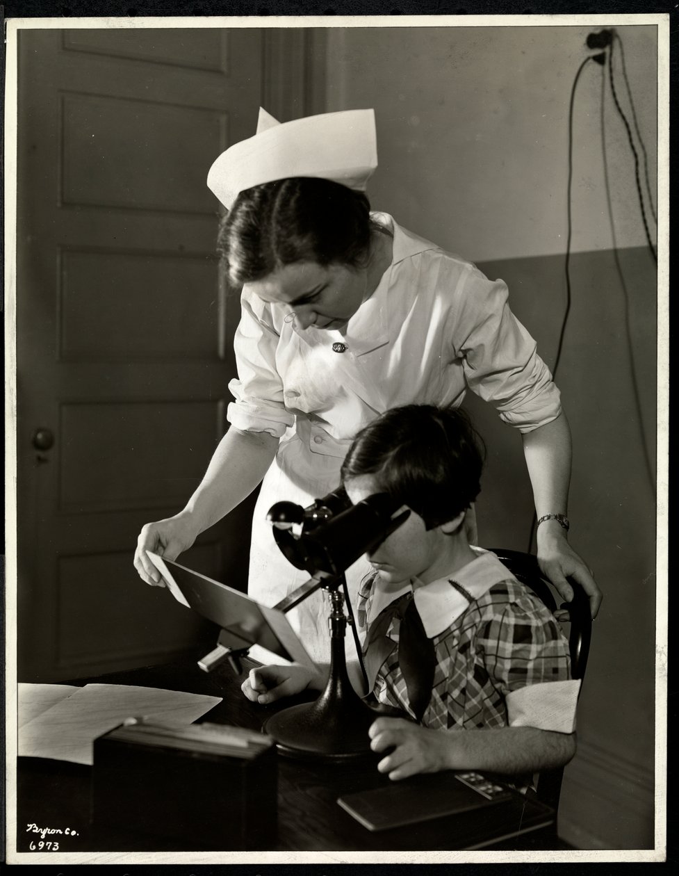 Verpleegster en een visueel gehandicapt meisje in de kliniek van de New York Association for the Blind, 114 East 60th Street, New York, 1934 door Byron Company