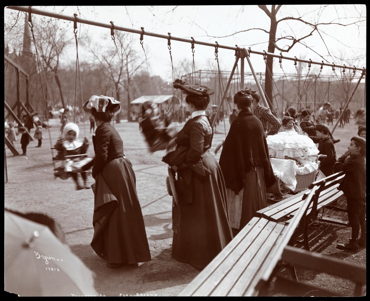 Zicht op een vrouw die kinderen op de schommels duwt in Tompkins Square Park, op Arbor Day, New York, 1904 door Byron Company