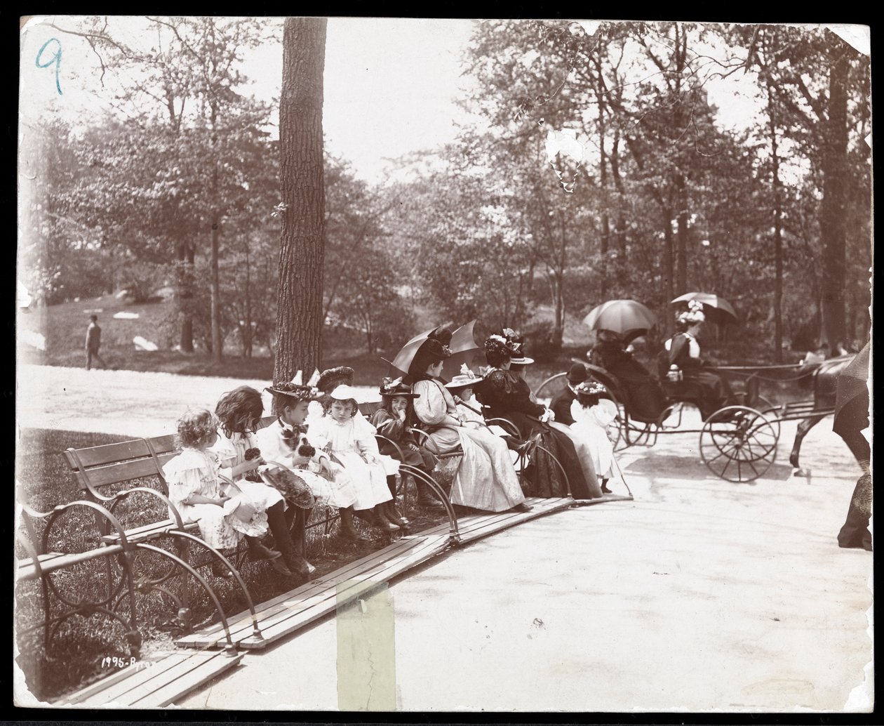 Zicht op vrouwen en kinderen zittend op banken in Central Park, New York, 1898 door Byron Company