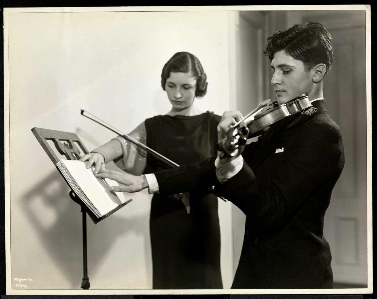 Vrouw leert een blinde jongeman viool spelen bij de New York Association for the Blind, 111 East 59th Street, New York, 1936 door Byron Company