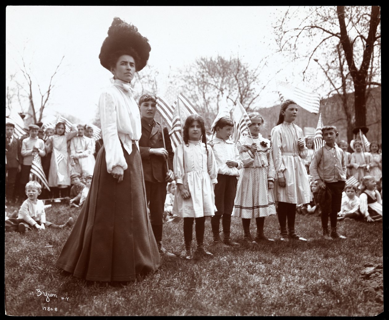 Vrouw met kinderen die vlaggen vasthouden op Arbor Day in Tompkins Square Park, New York, 1904 door Byron Company