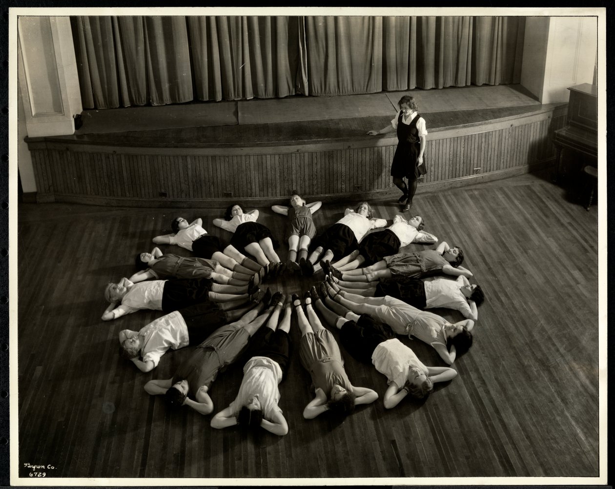 Jonge blinde vrouwen liggend in een sterpatroon op de vloer van de gymzaal bij de New York Association for the Blind, 111 East 59th Street, New York, 1933 door Byron Company
