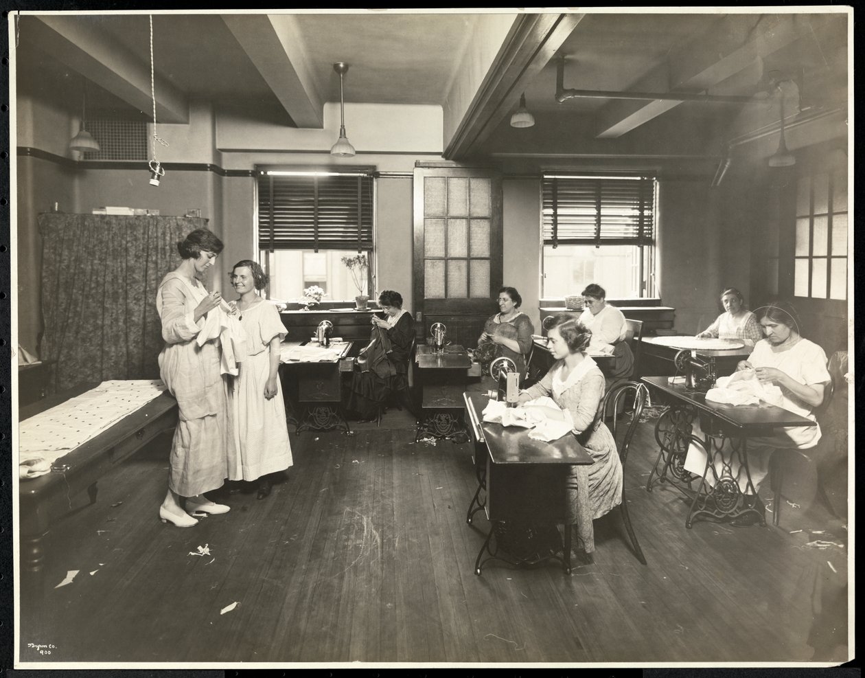 Blinde jonge vrouwen en een leraar die naaien in een klaslokaal bij de New York Association for the Blind, 111 East 59th Street, New York, 1921 door Byron Company