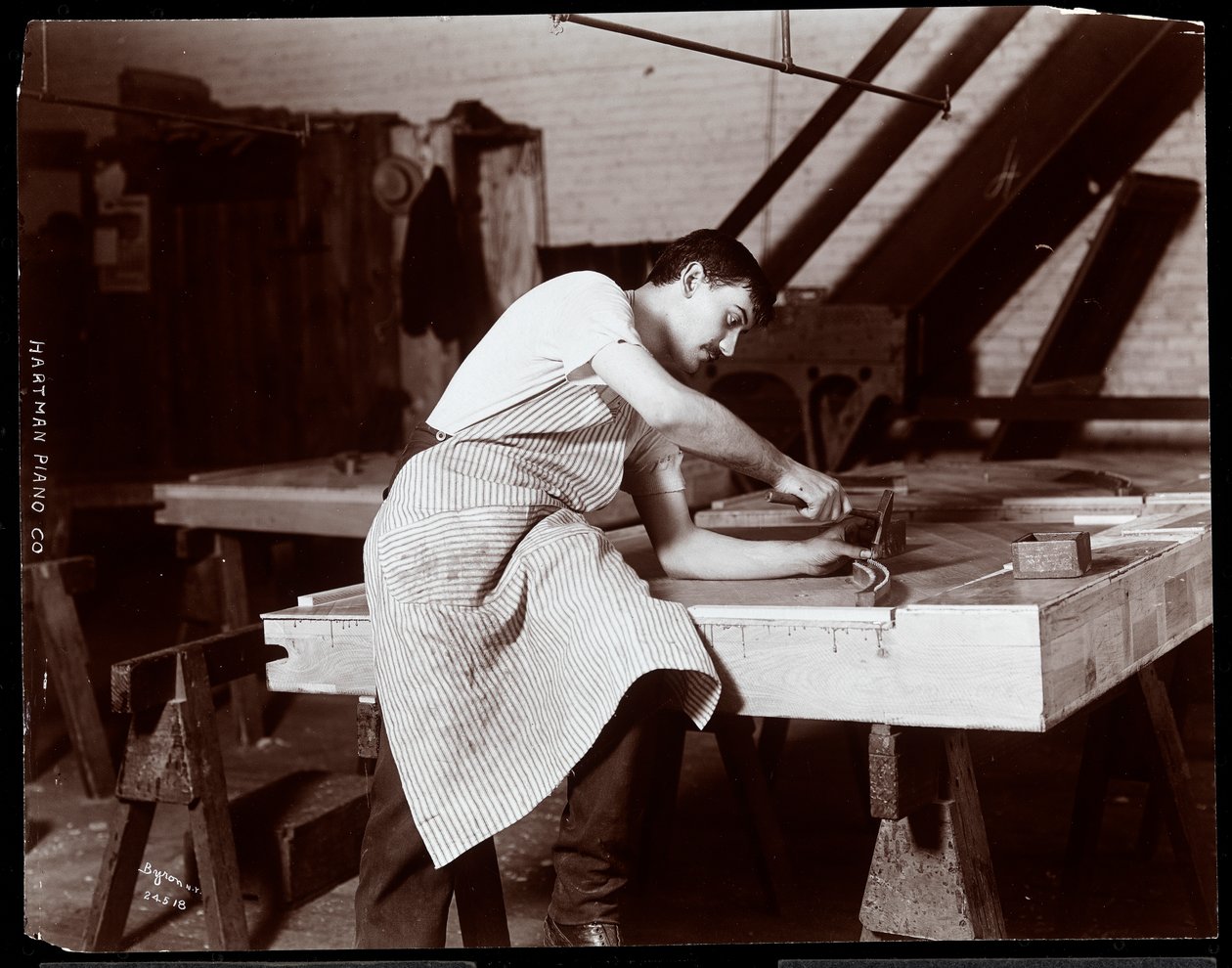 Man aan het werk in de Hardman, Peck und Co. pianofabriek, New York, 1907 door Byron Company