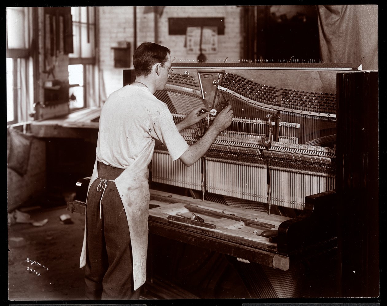 Man aan het werk in de Hardman, Peck und Co. pianofabriek, New York, 1907 door Byron Company