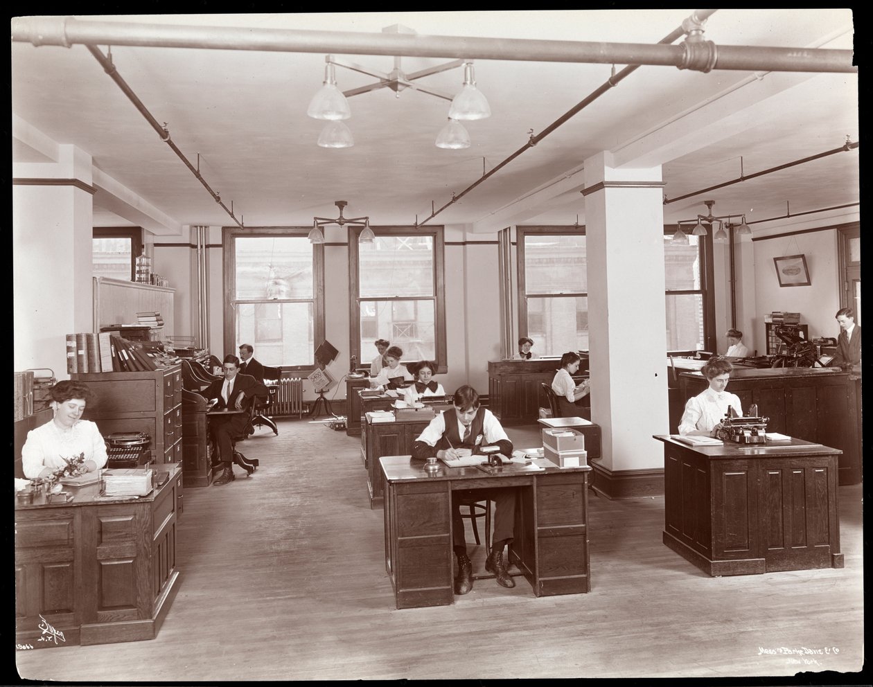 Mannen en vrouwen in een open kantoor bij Parke, Davis en Co., chemici, Hudson en Vestry Streets, New York, 1910 door Byron Company
