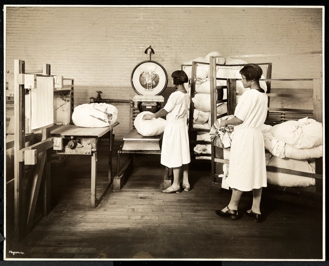 Twee Afro-Amerikaanse vrouwen die zakken wasgoed wegen bij de Carolyn Laundry in East Harlem, New York, 1928 door Byron Company
