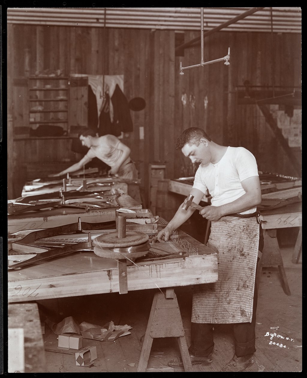 Twee mannen werken in de Harrington Piano Co. fabriek, 1907 door Byron Company