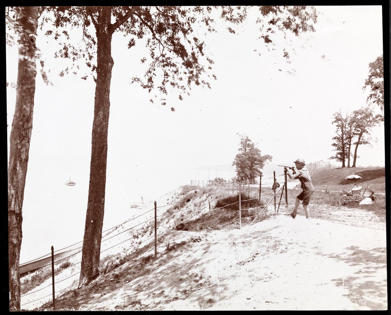 Zicht op een jongen met een verrekijker die naar de Hudson River kijkt vanuit Riverside Park, New York door Byron Company