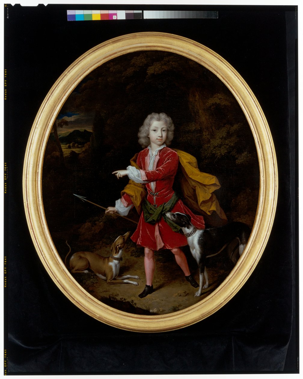 Een portret van een jonge man met een paar jachthonden in een bosrijk landschap door Constantin Netscher