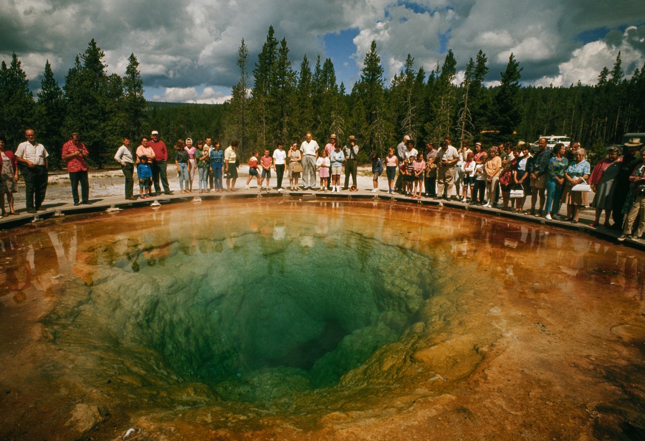 Parkbezoekers verzamelen zich rond blauwgroene, bloemvormige thermale poel. Yellowstone National Park. door Dean Conger