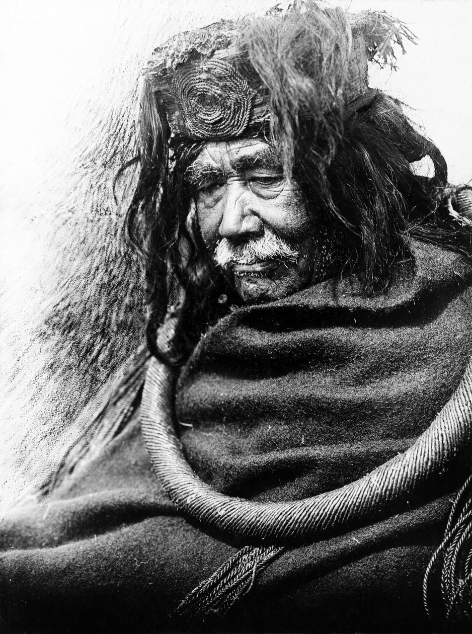 De Hamatsa, Nakoaktok c. 1910 Halflang portret van Nakoaktok man, naar links kijkend, met cederwortel ceremoniële lus. door Edward Sheriff Curtis