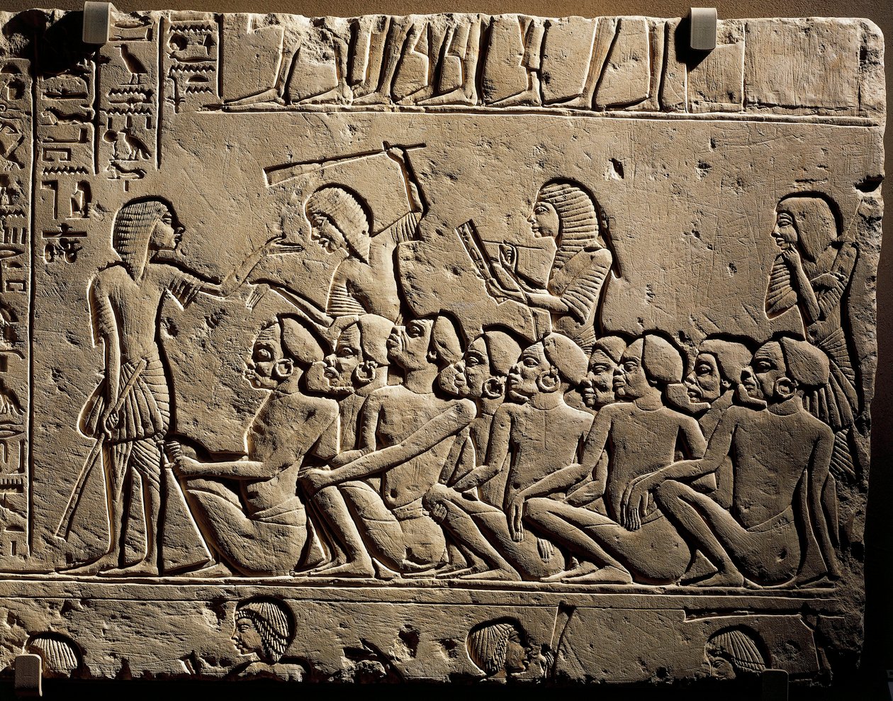 Een groep Negroid gevangenen omringd door bewakers gewapend met knuppels terwijl een schrijver een rapport opstelt, reliëf uit het graf van Horemheb in Saqqara door Egyptian 18th Dynasty