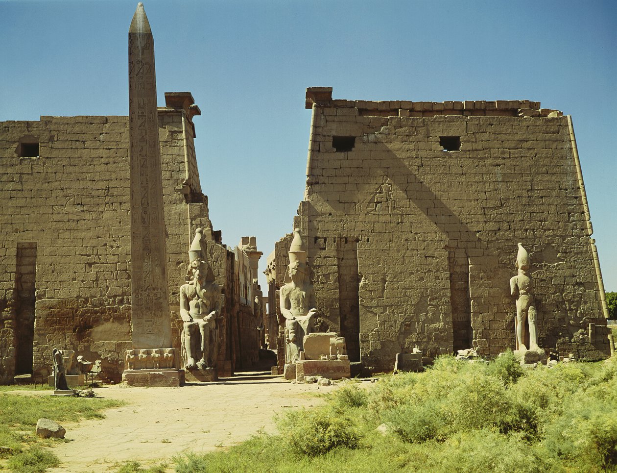 Gevel en eerste pyloon met twee zittende beelden van Ramses II en de overgebleven obelisk door Egyptian 19th Dynasty
