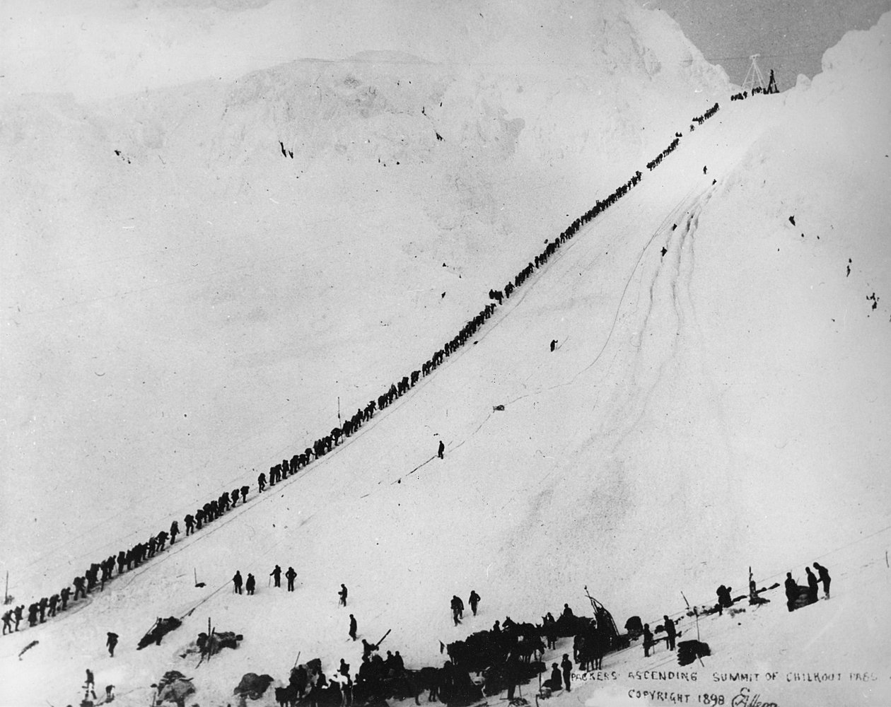 Pakkers beklimmen de top van de Chilkoot Pass, uit 