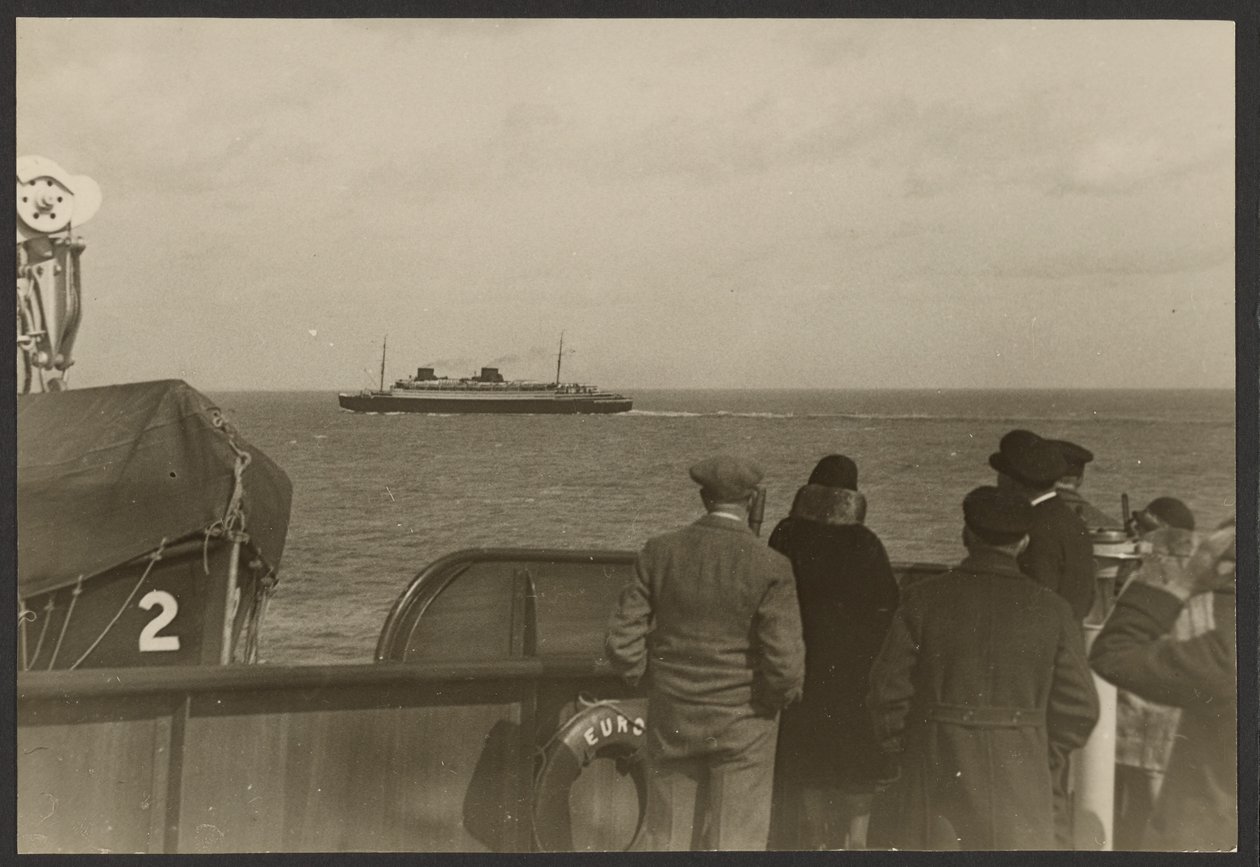 [Groep mensen op het dek van een schip die kijken naar een ander schip dat in de verte voorbij vaart]. door Erich Salomon