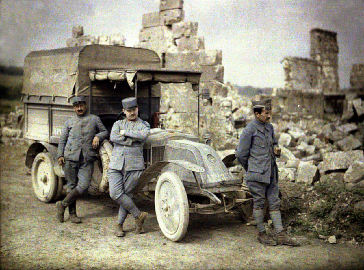 Drie Franse soldaten geparkeerd voor een zwaar beschadigd gebouw met een kleine vrachtwagen, Aisne, Frankrijk, 1917 door Fernand Cuville