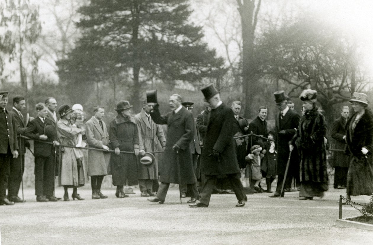 Koning George V, die zijn hoed opheft naar de menigte vooraan zijn gevolg, tijdens een bezoek aan de Londense dierentuin om officieel het aquarium te openen, april 1924 door Frederick William Bond