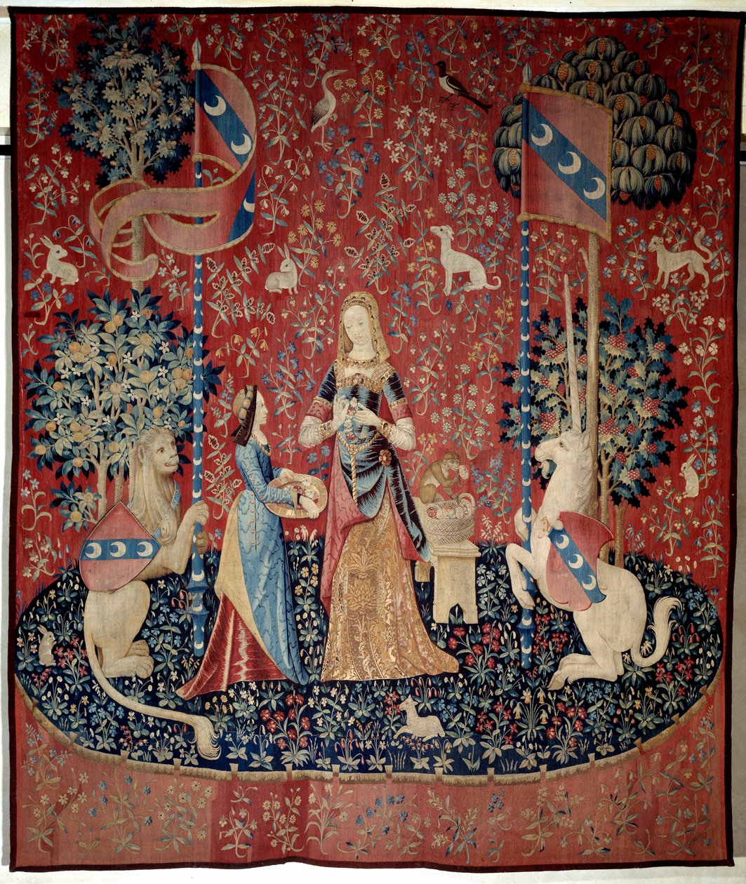 Gordijn van de Dame met de Eenhoorn: allegorie van geur. Een jonge vrouw die een kroon van anjers vasthoudt, omringd door een leeuw, een eenhoorn, een aap, konijnen door French School