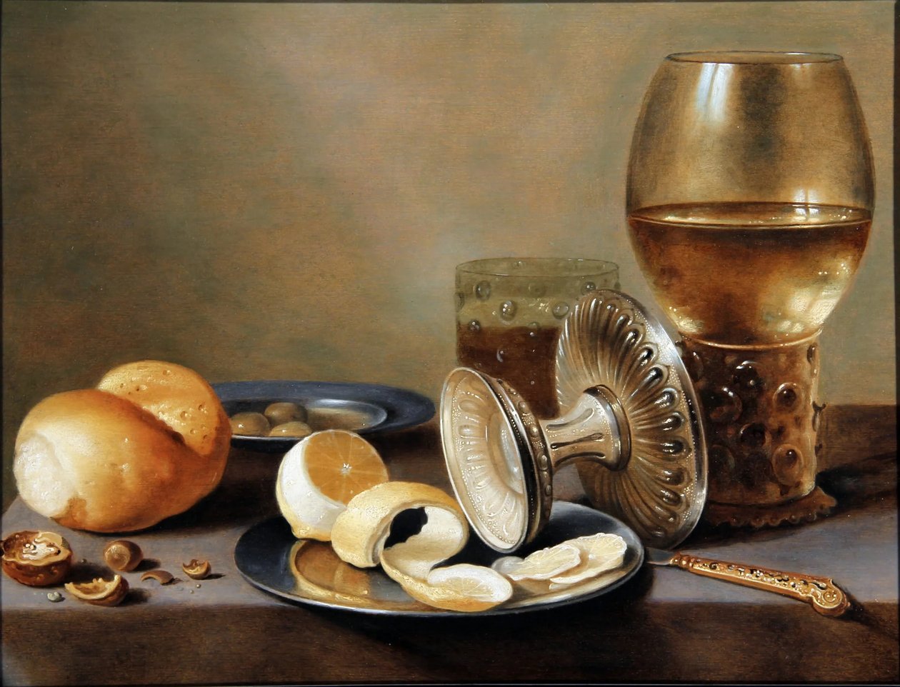 Monochroom Banketje met twee tinnen schotels, een omgedraaide zilveren tazza, een verguld mes, een glas met bier, een roemer met wijn, een broodje, noten, olijven en een half geschilde citroen door Hans van Sant