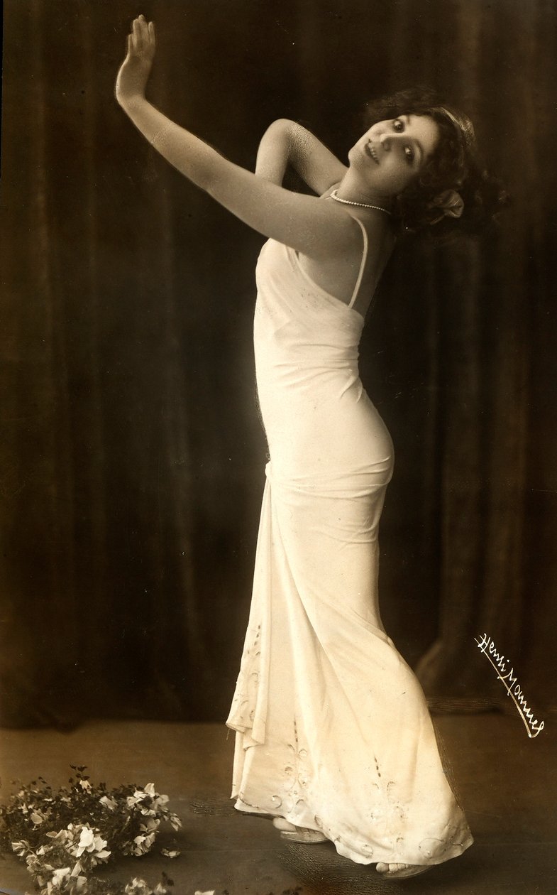 Portret van de Franse actrice Regina Badet in een evocatieve pose, gekleed in een lange witte jurk door Henri Manuel