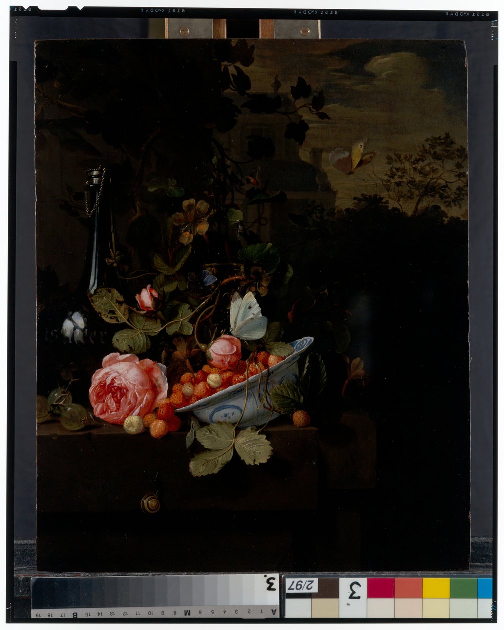Stilleven met een kom aardbeien, een roos en een fles op een richel, een landschap daarachter door Jan Mortel