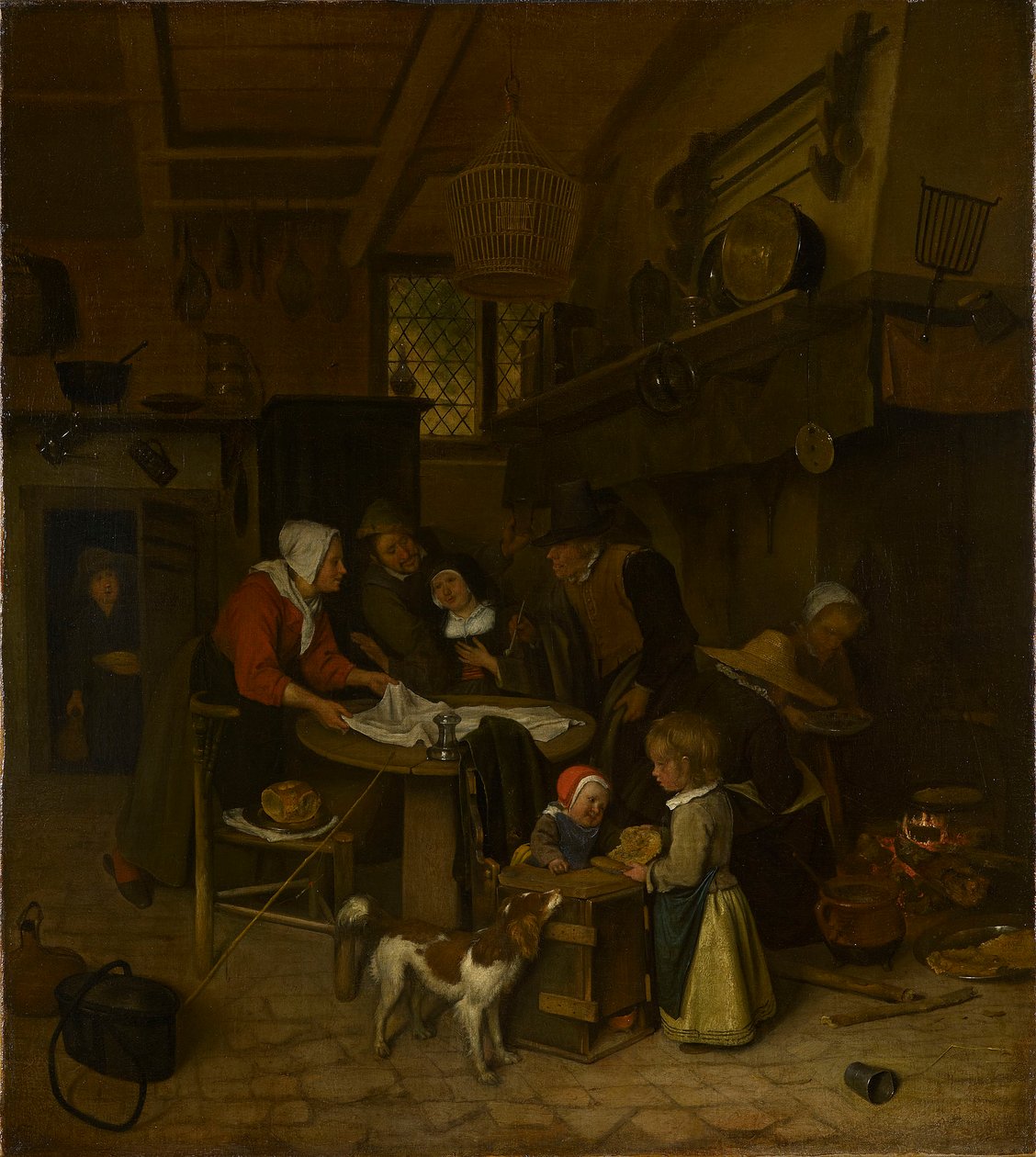 Een scène in een boerenkeuken met een bediende die het laken legt door Jan Steen
