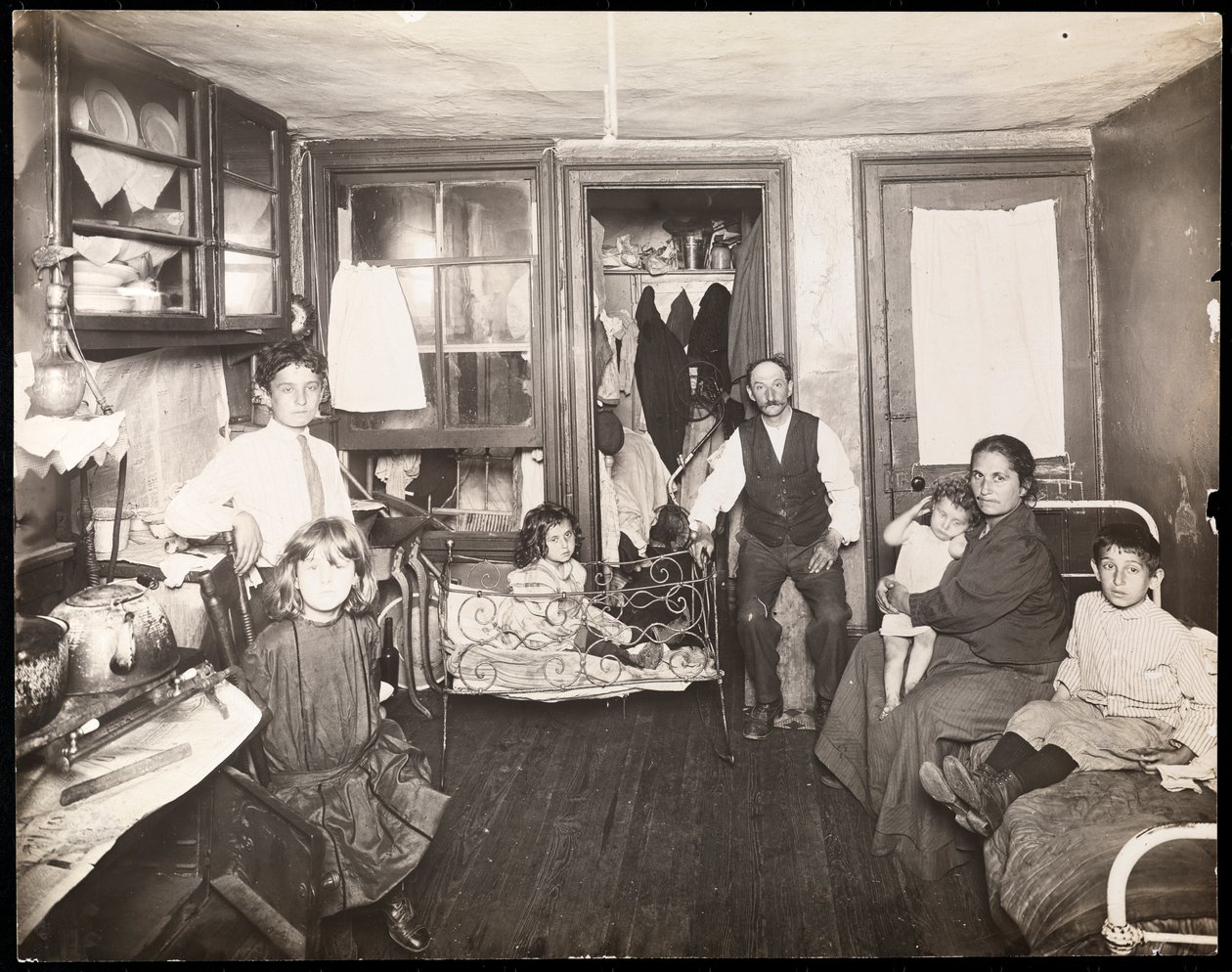 Familie in kamer in huurkazerne, ca. 1910 door Jessie Tarbox Beals
