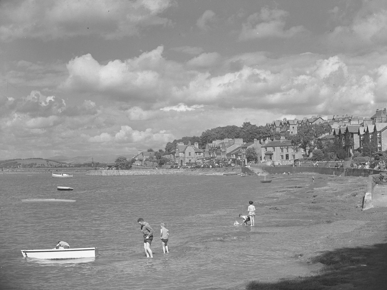Mensen spelen in boten bij hoog water in Arnside met Albion Hotel op achtergrond door Joseph Hardman